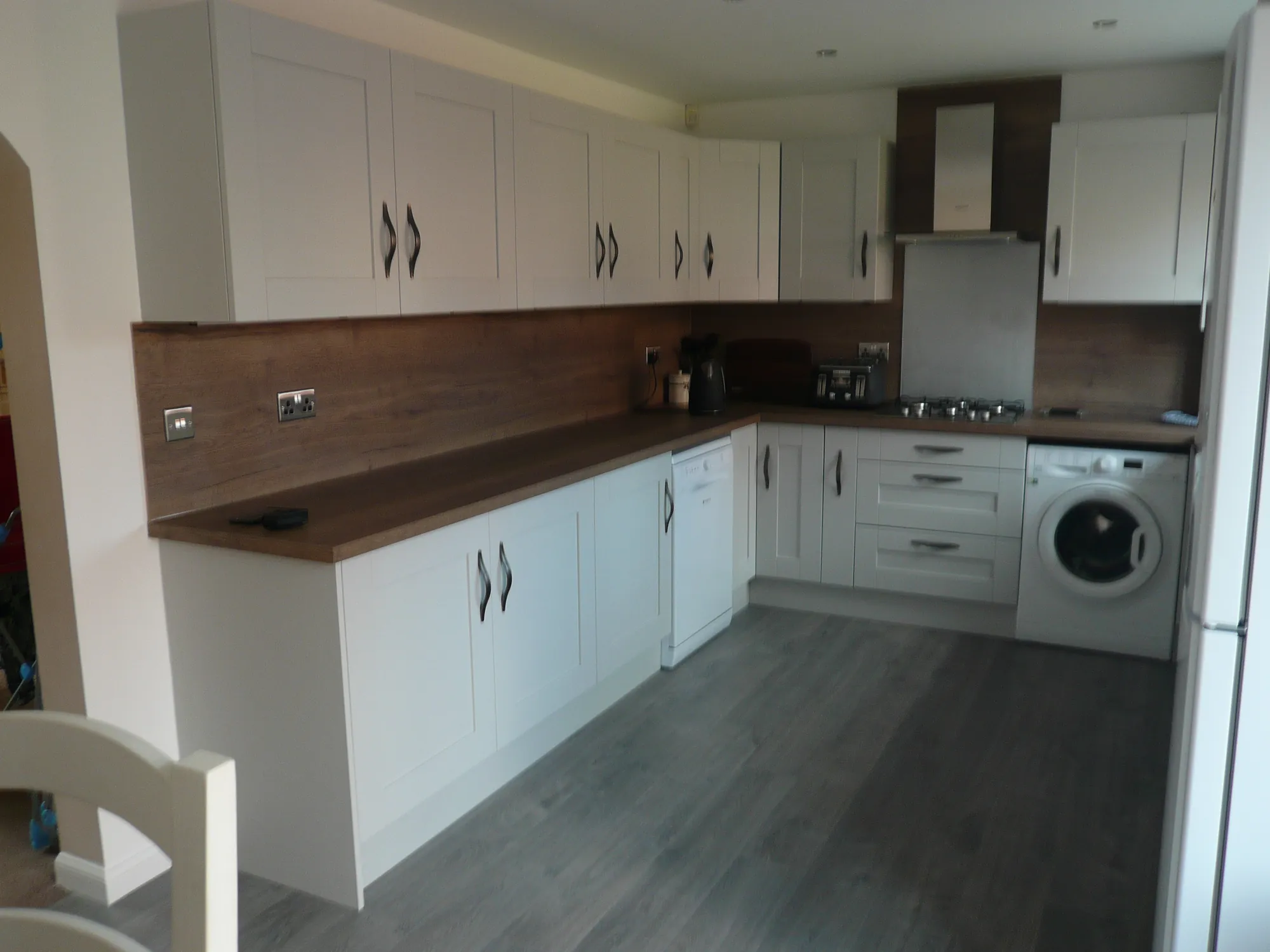 Full-height worktop-material panels above a dark worktop in a fitted Glasgow kitchen