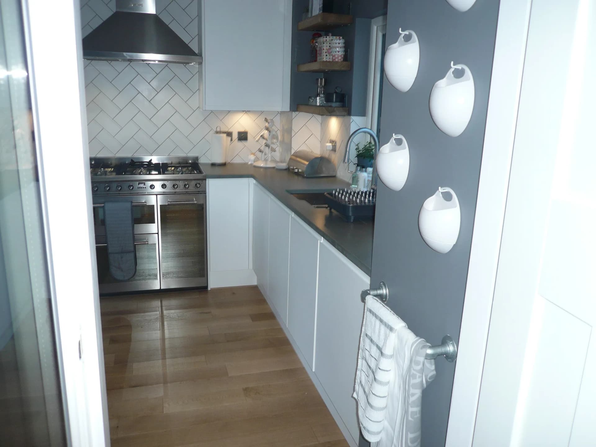 Smeg range cooker and herringbone tiled splashback seen from the utility room doorway