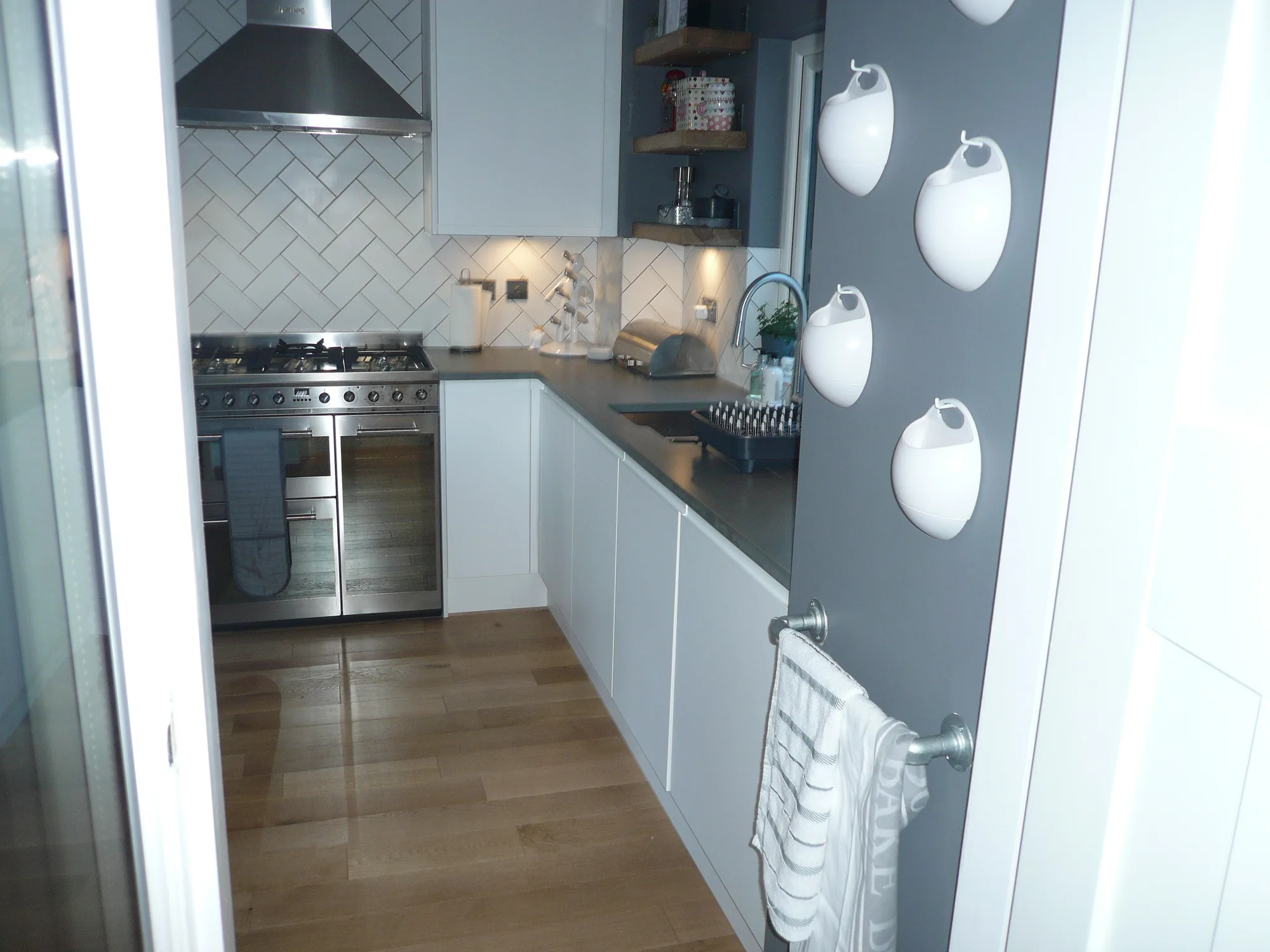 Smeg range cooker and herringbone tiled splashback seen from the utility room doorway