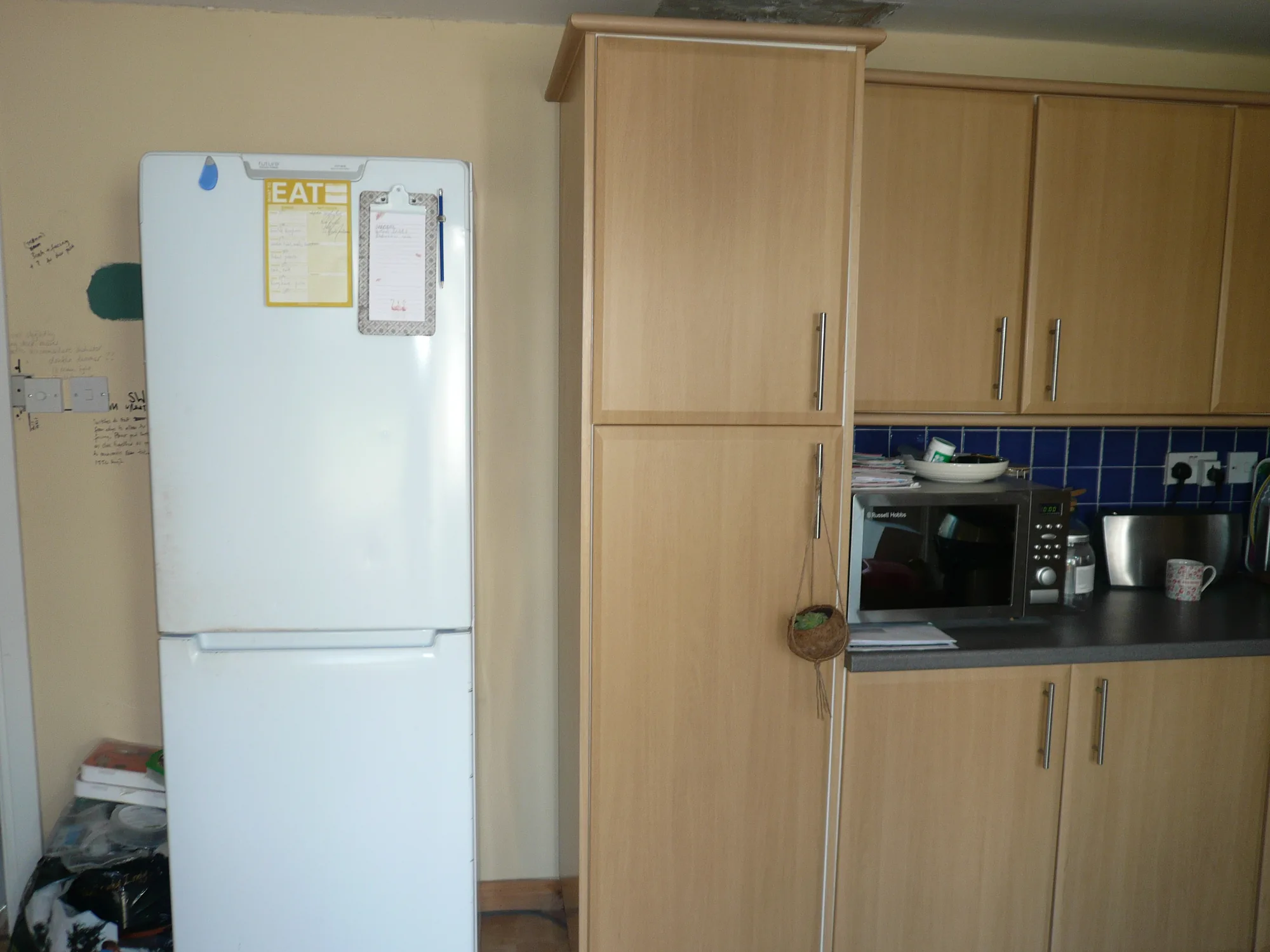 The old beech kitchen before renovation, with planning notes pencilled onto the bare wall