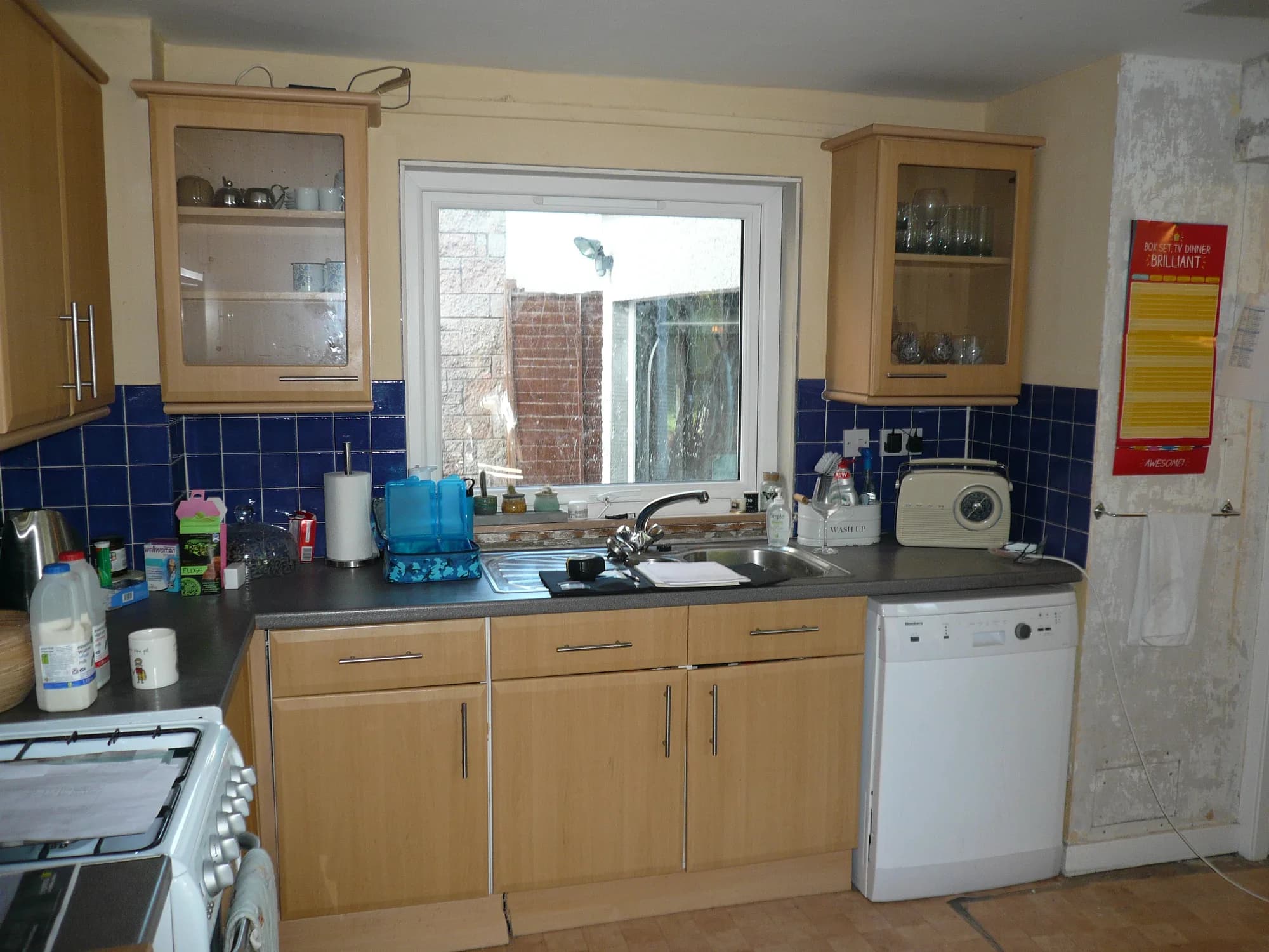 Beech units, blue tiles and a freestanding cooker in the kitchen before renovation