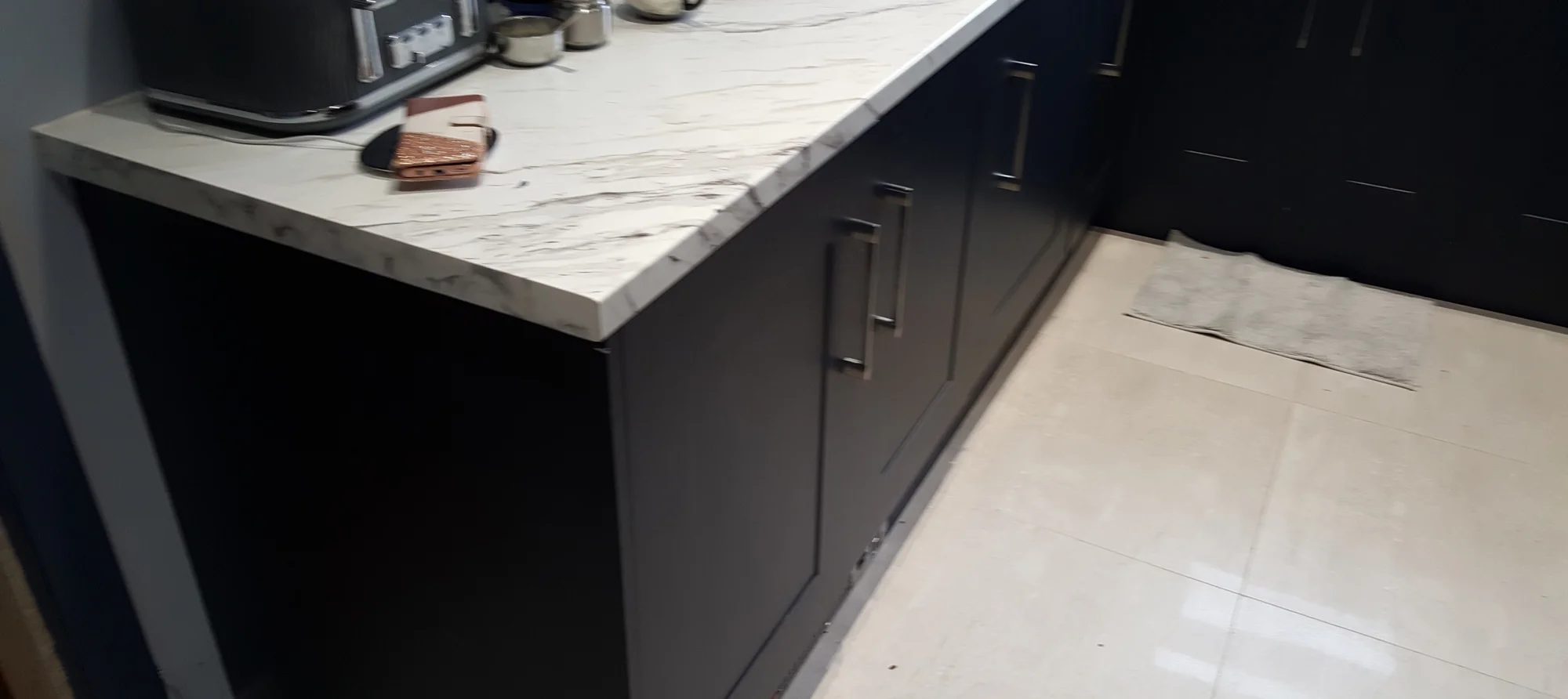 End of the drawer run in the indigo Oxford kitchen, showing the squared marble-effect worktop edge